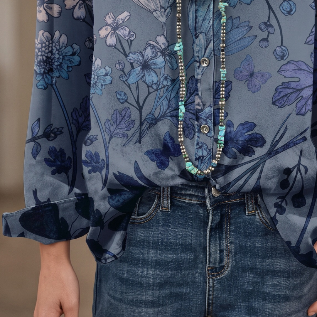 Blusa feminina com gola banda e decote em V, abertura parcial de botões, mangas bufantes curtas com punhos franzidos, estampa floral, caimento