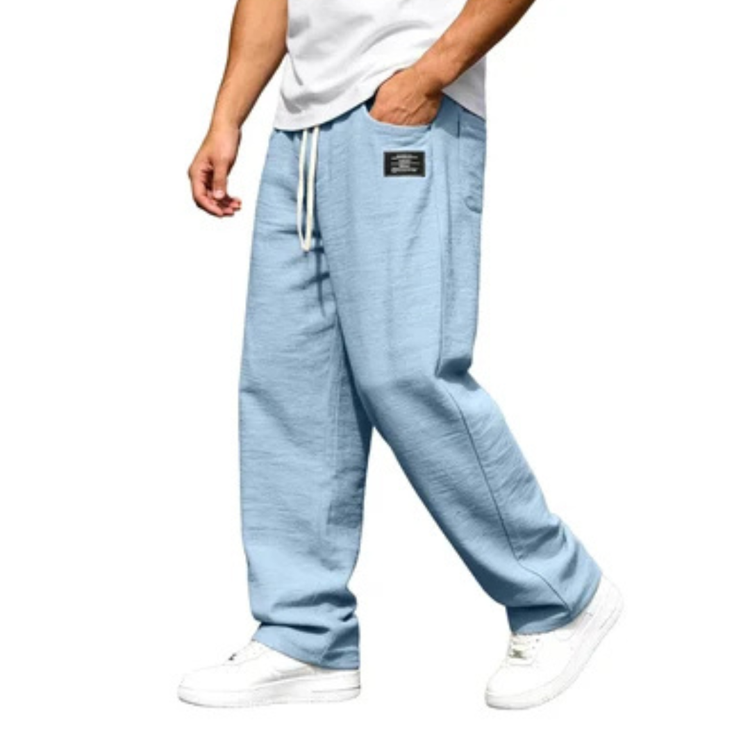 Calça masculina de perna reta com cós elástico e cordão, bolsos laterais e detalhe de etiqueta
