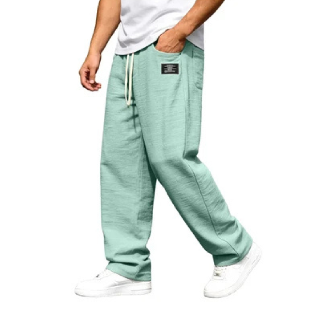 Calça masculina de perna reta com cós elástico e cordão, bolsos laterais e detalhe de etiqueta