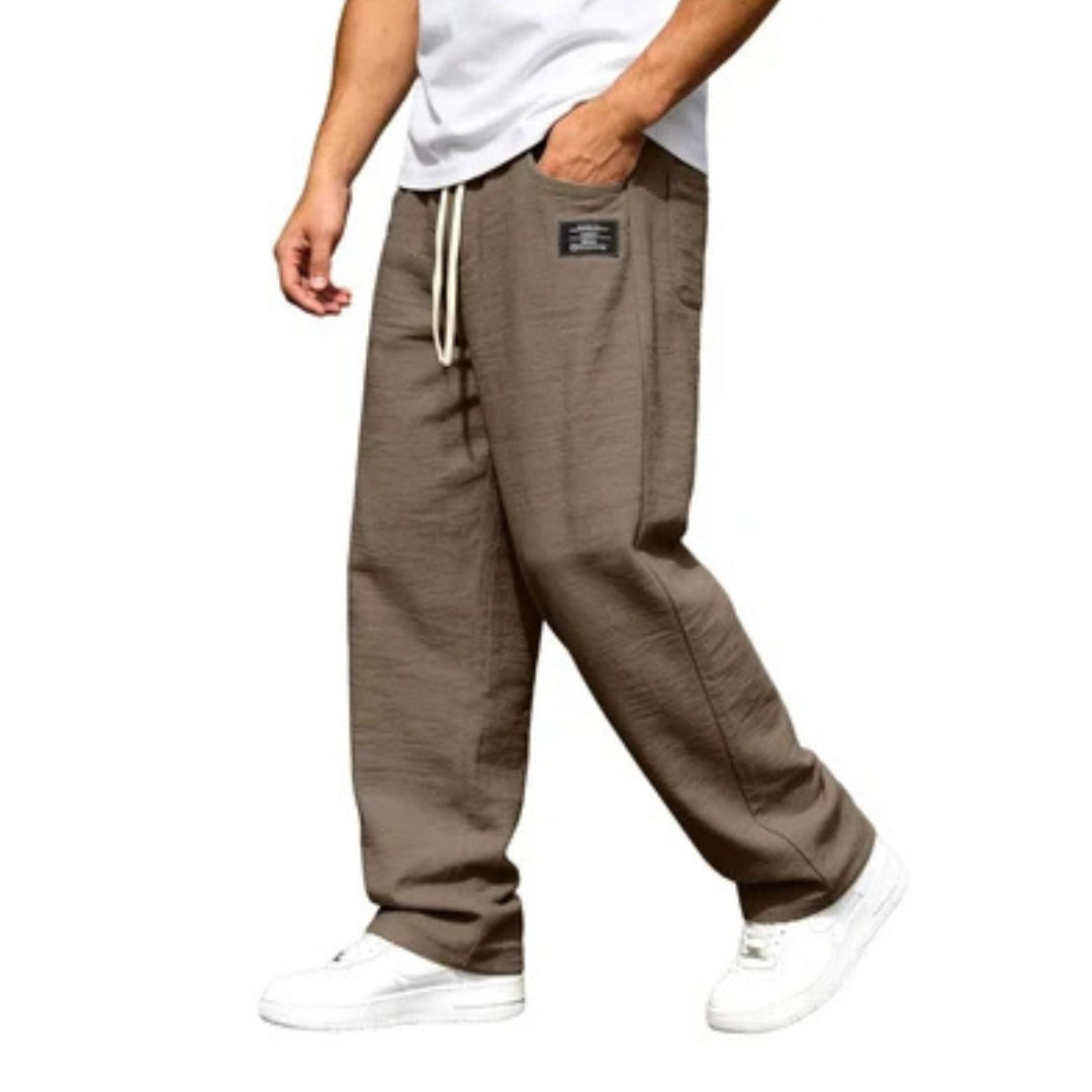 Calça masculina de perna reta com cós elástico e cordão, bolsos laterais e detalhe de etiqueta