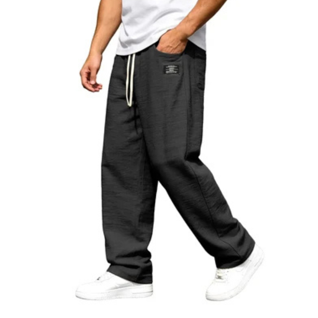 Calça masculina de perna reta com cós elástico e cordão, bolsos laterais e detalhe de etiqueta