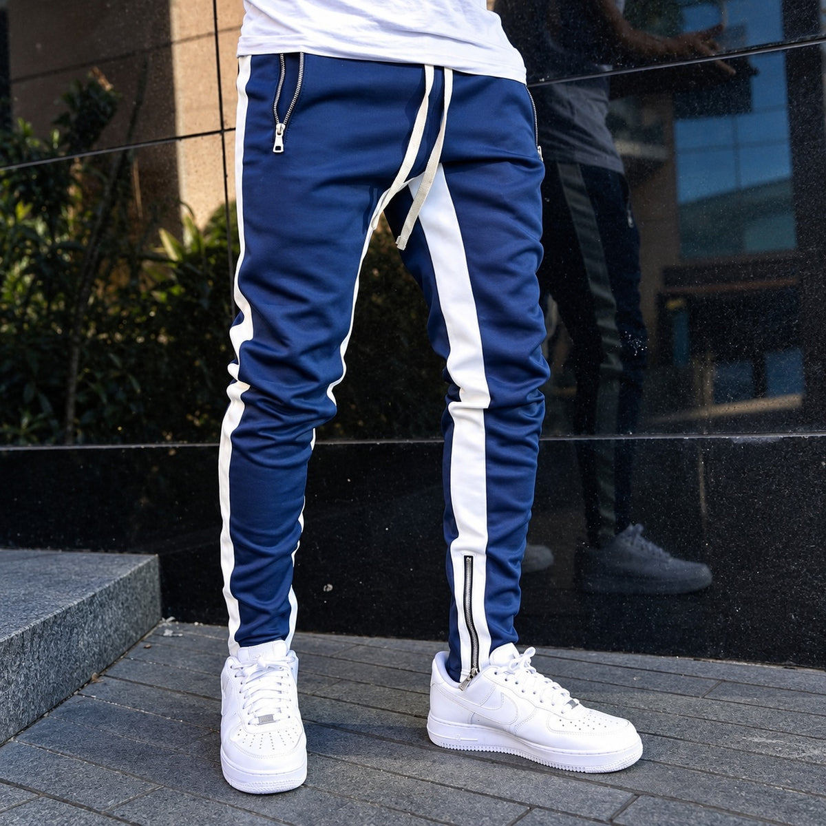 Calças jogger masculinas com listras contrastantes e bolsos com zíper