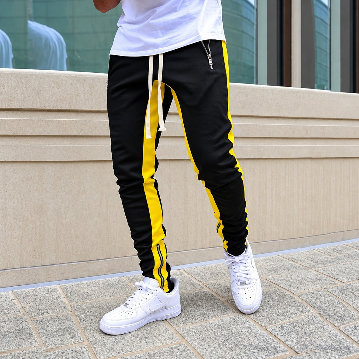 Calças jogger masculinas com listras contrastantes e bolsos com zíper