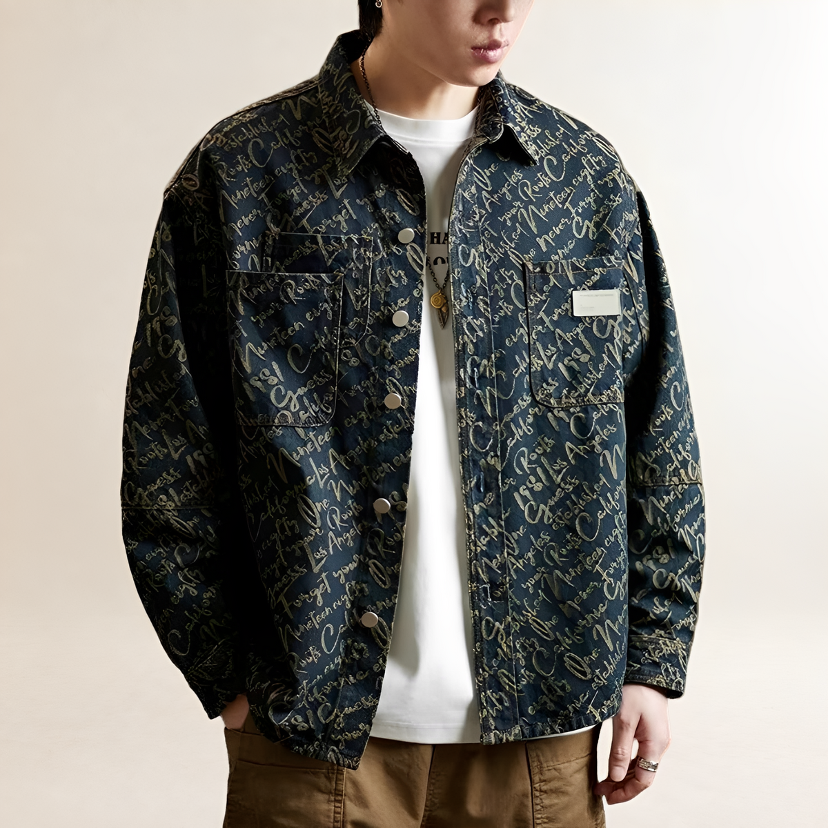 Camisa-jaqueta masculina com fechamento de pressão frontal, bordado por toda a peça e bolsos peitorais, corte relaxado