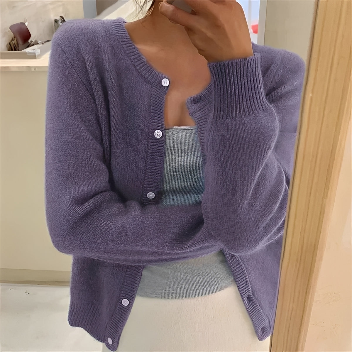 Cardigan feminino com fechamento de botões, punhos canelados e corte regular