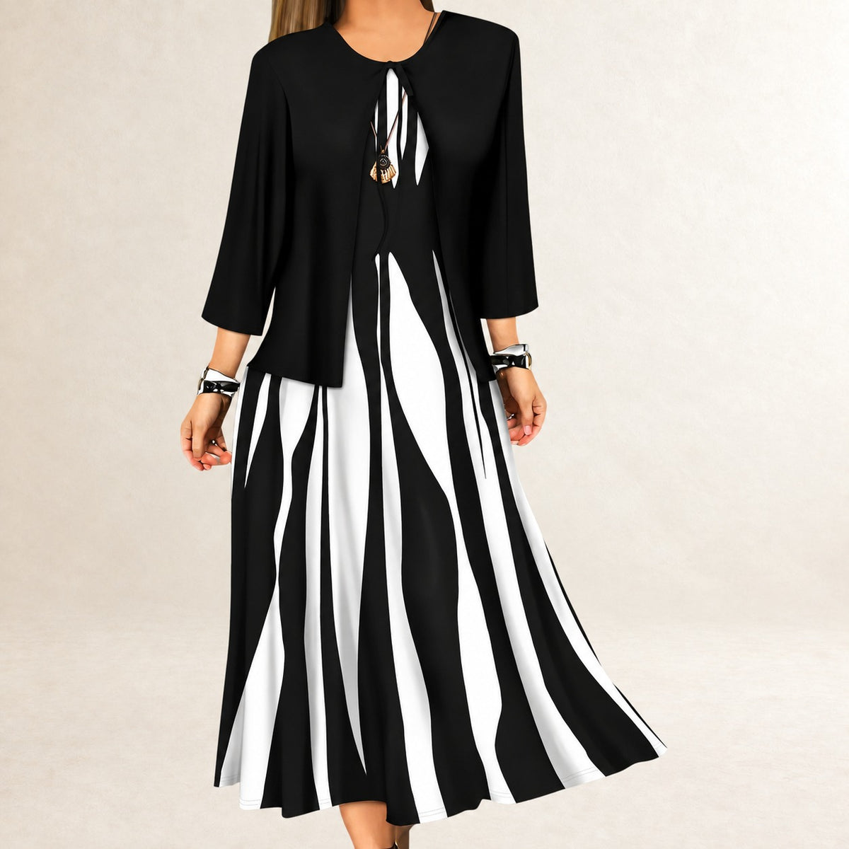 Conjunto feminino de vestido em duas peças - Vestido longo sem alças, silhueta linha A; jaqueta aberta com mangas ¾ e laço central, estampa ondulada