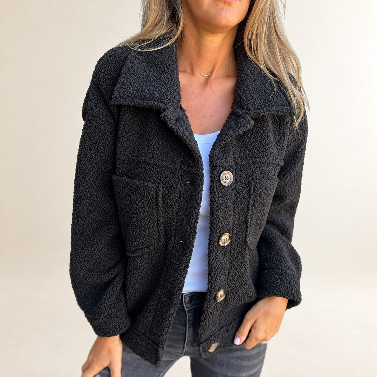 Jaqueta feminina curta com fechamento frontal por botões, gola de lapela, textura texturizada e bolsos patch, caimento relaxado