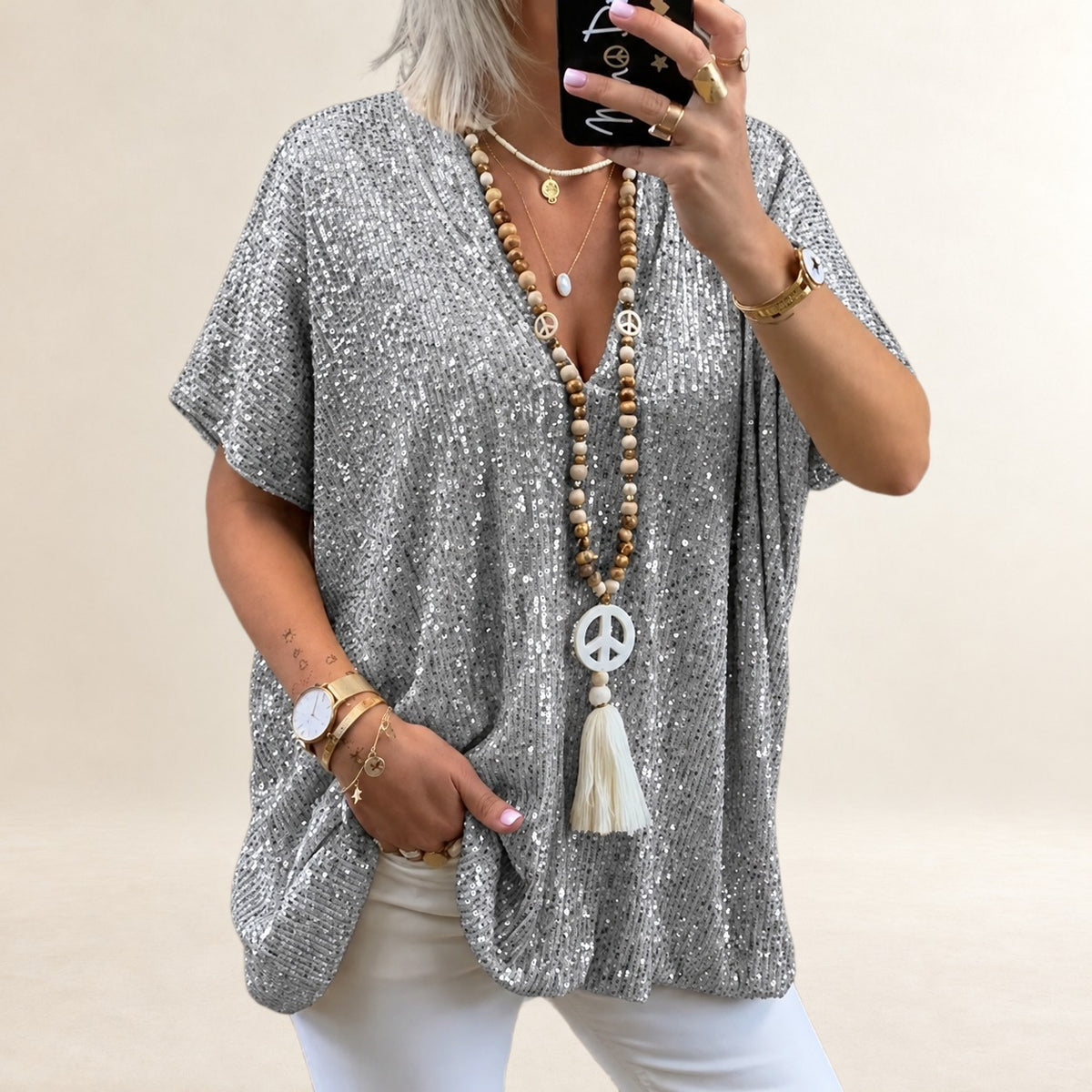 Top feminino decote em V, manga curta, caimento solto e comprimento até o quadril com acabamento cintilante