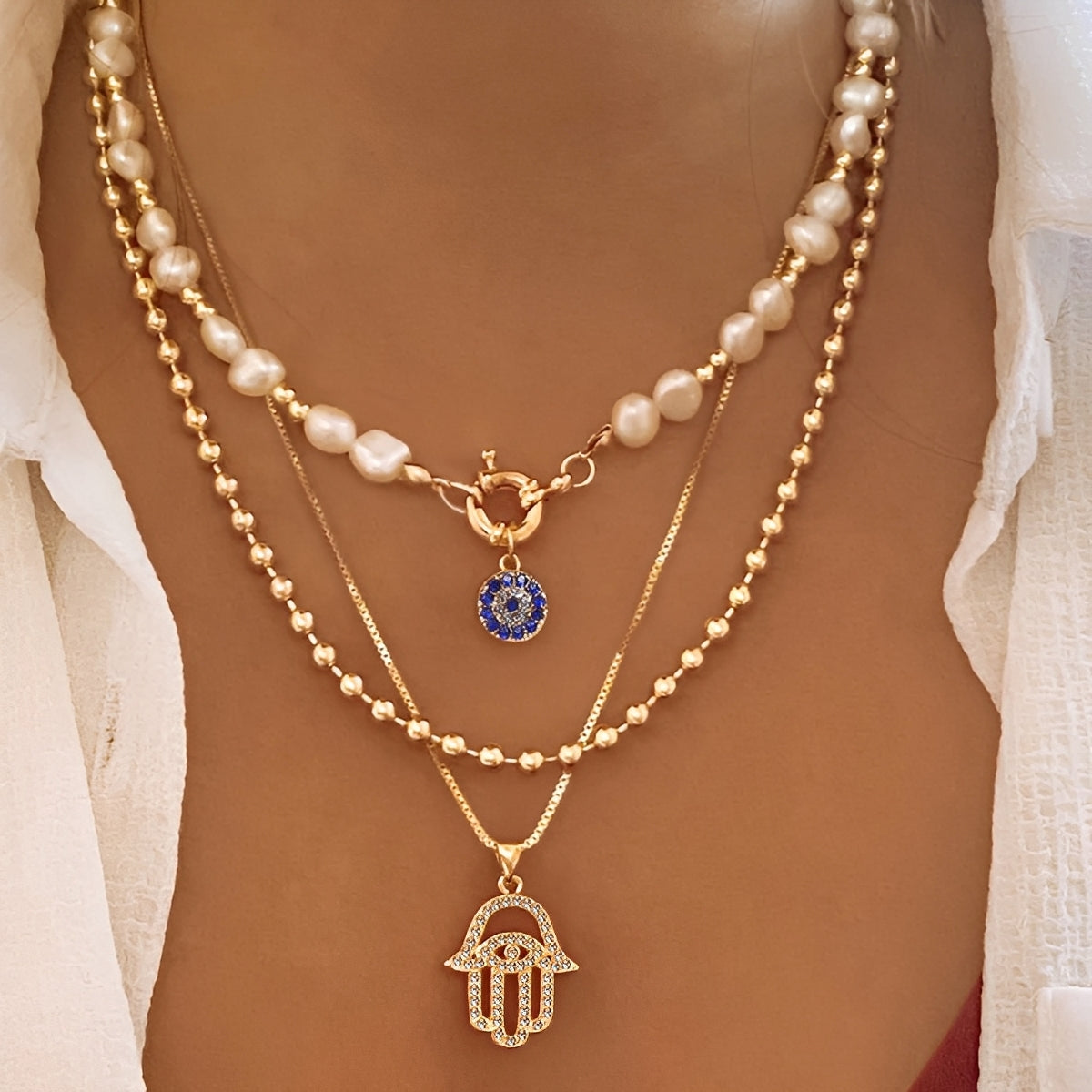 Nadia – Colar com várias fileiras de pérolas e mão de Hamsa