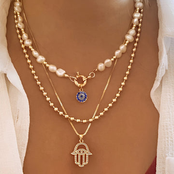 Nadia – Colar com várias fileiras de pérolas e mão de Hamsa